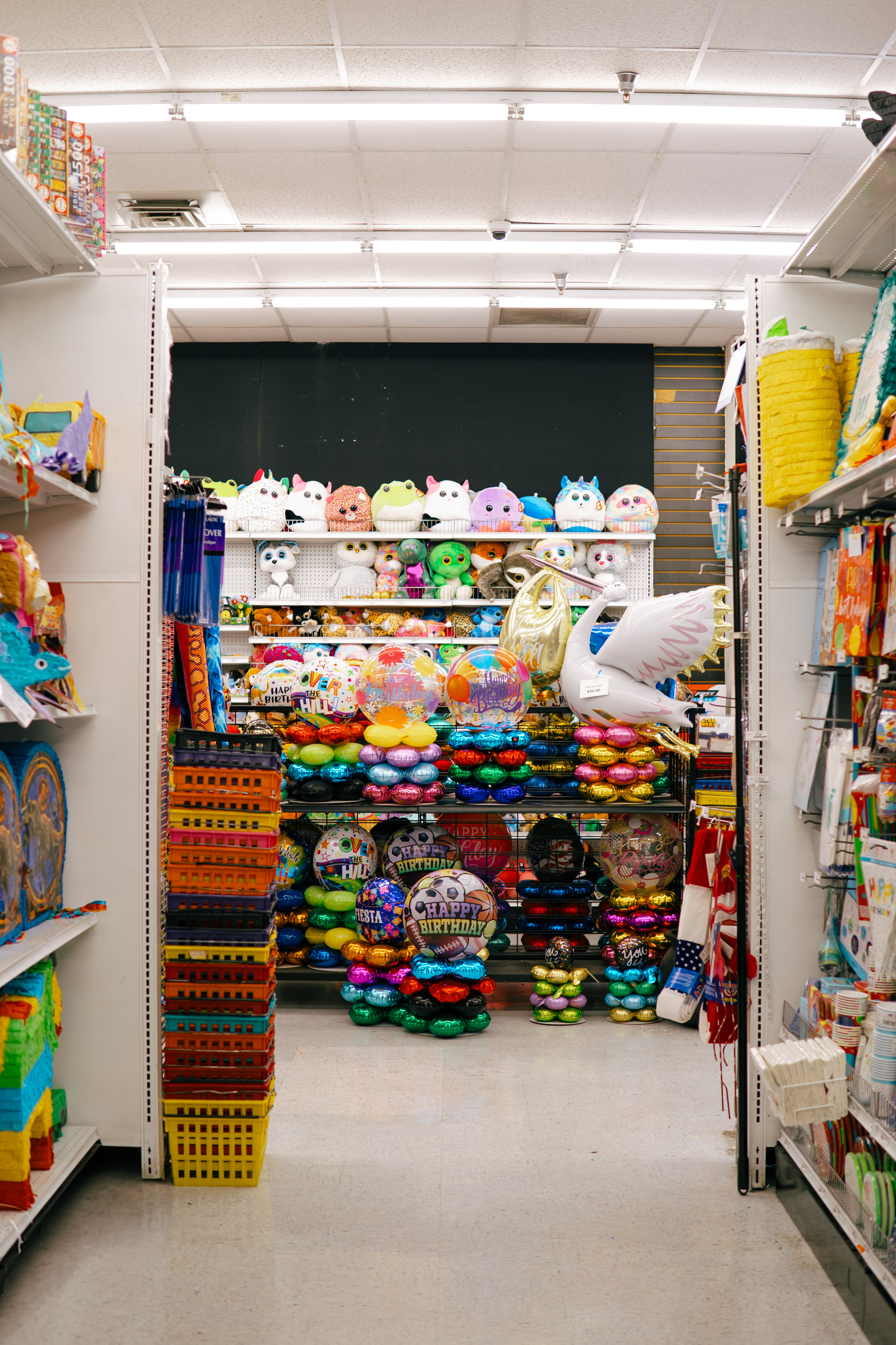 PartyWorks grand center retail aisle with balloon towers, piñatas, and plushies